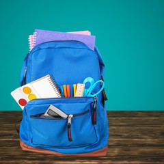 Open blue school backpack on wooden table