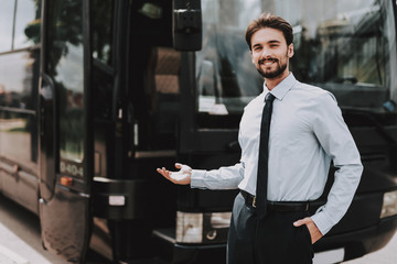 Young Smiling Businessman Standing in front of Bus