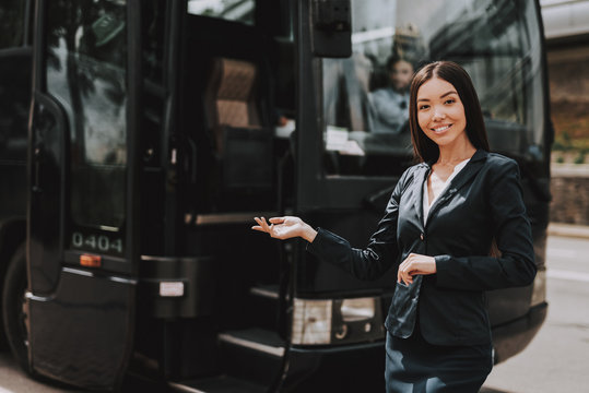 Young Smiling Businesswoman Standing in front of Bus