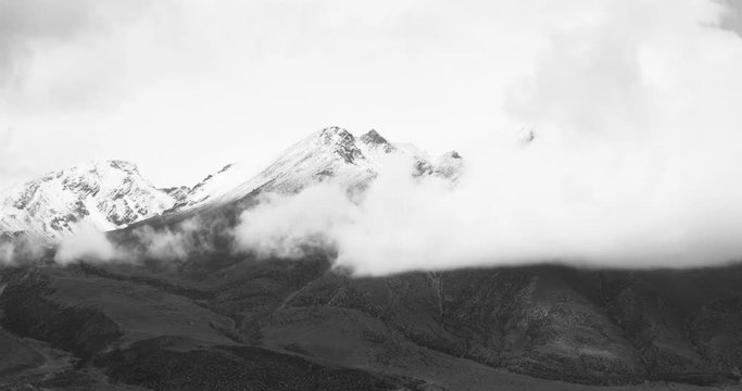 4k time lapse of clouds mass rolling over Tibet snow-Covered mountains,Danggula(Tanggula) Mountains in xizang Plateau,roof of the World.	