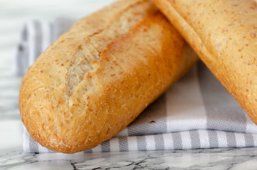 Freshly baked French baguettes on white wooden table. Top view, close up