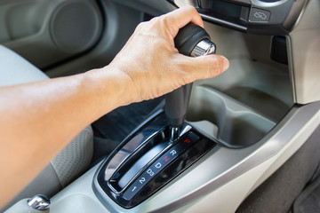 Men's arm hold control auto gear for car shifting into P  will try to engage the parking pawl to...