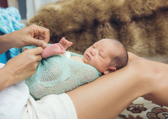 Fototapeta na wymiar woman holding a newborn baby on her legs