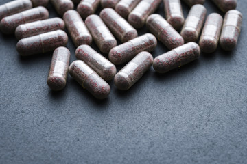 Transparent Drugs, Pills, Vitamins (Bilberry, Ginkgo, Lutein) Scattered On A Gray Slate Background. Medical Series. Free Space For Text. Close Up. Angle View. Rustic Style.