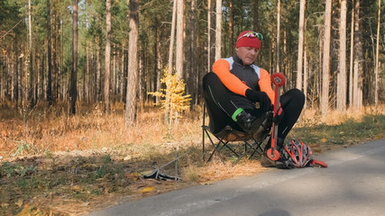 Training an athlete on the roller skaters. Biathlon ride on the roller skis with ski poles, in the...