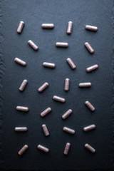 Transparent Drugs, Pills, Vitamins (Bilberry, Ginkgo, Lutein) Scattered On A Gray Slate Background. Medical Series. Top View.