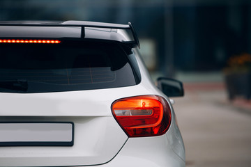 Rear view of modern sport hatchback. Carbon spoiler on the trunk car