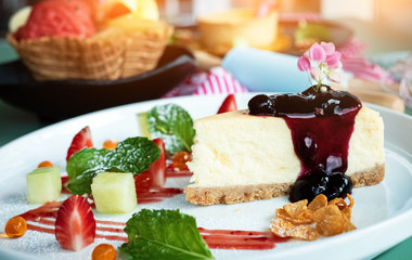 Closeup Cheese cake with raspberry topping in white dish,blurry lightaround