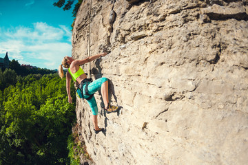 Obraz premium The girl climbs the rock.