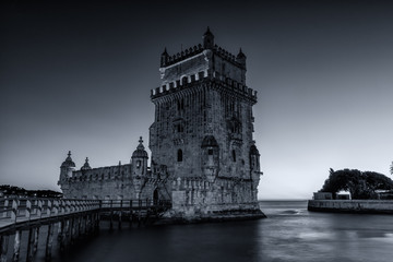 Fototapeta na wymiar Black & white photograph of the Belem Tower (Belém Tower) at sunset. A medieval castle fortification on the Tagus river of Lisbon Portugal
