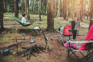 Asian women travel natural relax . Sitting working using a notebook. in the hammock. campsite on the national park  Doi inthanon at Chiangmai. in Thailand