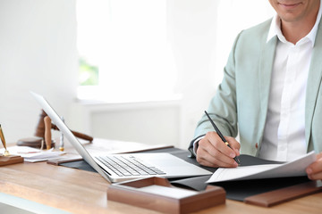 Male notary signing document at table in office, closeup - obrazy, fototapety, plakaty