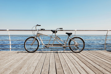 Tandem bike near sea on sunny day - obrazy, fototapety, plakaty