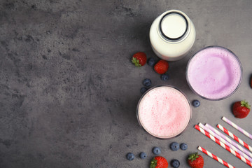 Flat lay composition with delicious milk shakes and space for text on grey background