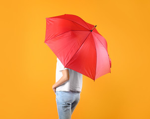 Woman with red umbrella on color background