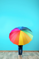 Little boy with rainbow umbrella near color wall. Space for text