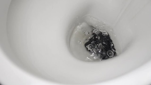 The phone falls into the toilet water. Slow motion.
