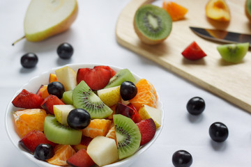 Healthy breakfast with kiwi, oranges, plums and other fruits.