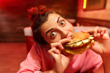 Girl with an appetite eats a big hamburger