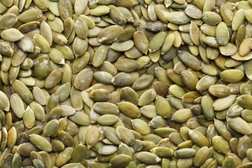 Shelled raw pumpkin seeds as background, top view