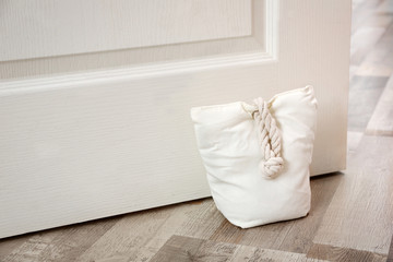 Stuffed bag holding wooden door at home