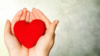 Fototapeta premium Hands of young woman holding red heart