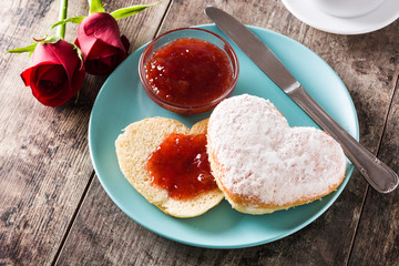 Valentine's Day breakfast with coffee, heart-shaped bun and berry jam.

