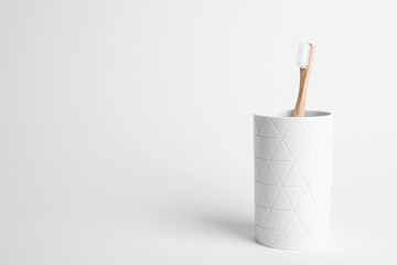 Holder with eco bamboo toothbrush on white background. Space for text