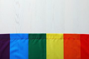 Rainbow gay flag on wooden background, top view with space for text. LGBT concept