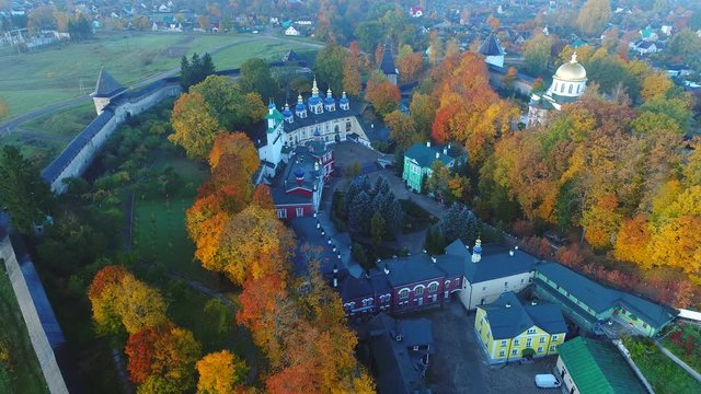 View on the temples of the Holy Dormition Pskovo-Pechersky monastery, Golden autumn (aerial video). Pechora, Russia 