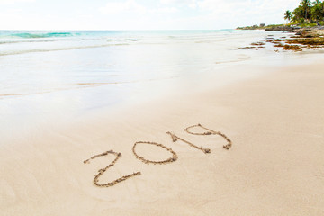 New Year 2019 written in sand write on tropical beach