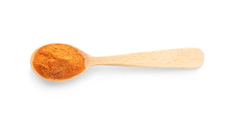 Wooden spoon with red pepper powder on white background, top view