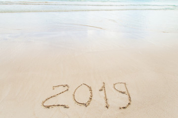 New Year 2019 written in sand write on tropical beach