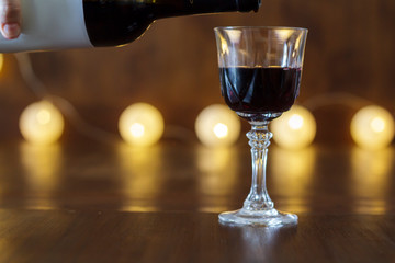 Red wine pouring into crystal glass