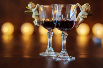 Two glasses of red wine with Christmas decoration with lights in the background