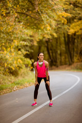 Young woman have a break during training in the autumn forest