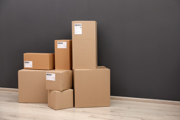 Stacked parcel boxes on floor against grey wall