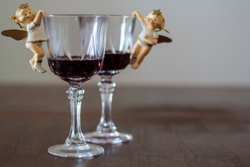 Two glasses of red wine with Christmas angels decoration