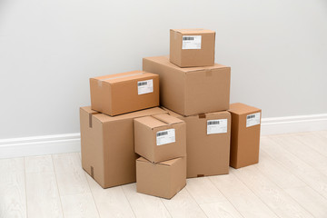 Stacked parcel boxes on floor against light wall