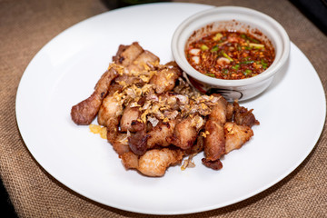 Fried sliced pork with garlic and pepper with purple rice Thai Recipes in White plate.