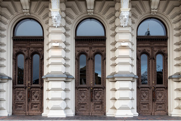 Three wooden doors to a stone building