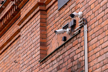Surveillance cameras on red brick wall