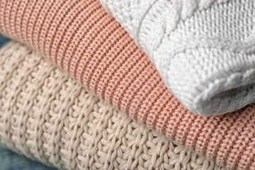 Fototapeta na wymiar Stack of folded warm knitted sweaters, closeup