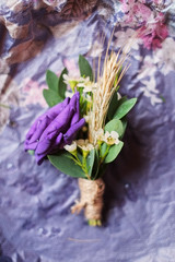 Gentle groom's boutonniere purple lies on a wooden background