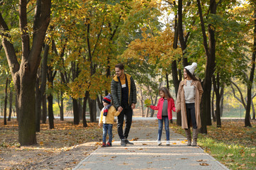 Happy family with children spending time together in park. Autumn walk
