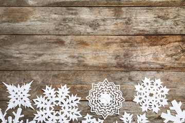 Composition with snowflakes and space for text on wooden background, top view. Festive winter design