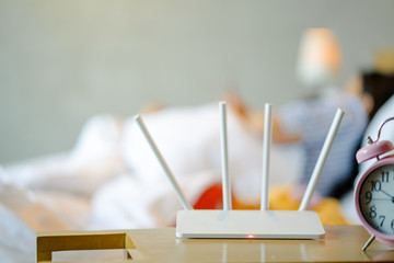 wireless router and a young man using a smartphone on bedroom at home