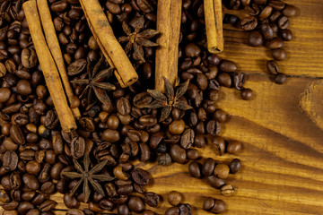 Coffee beans, cinnamon sticks and star anise on rustic wooden background