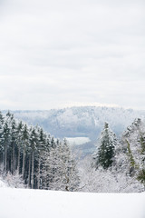 Beautiful winter landscape with snow covered trees and mountains and blue cloudy skies at frosty afternoon in Germany