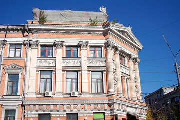 Old urban building facade with neoclassical architecture on autumn day